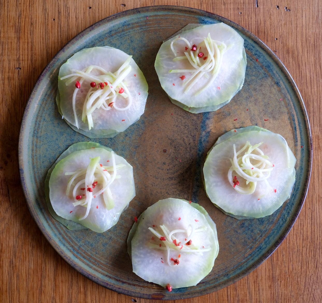 Chou rave • Truite fumée 

La belle surprise samedi au marché : Chloé et Hadrien abc_de_saison ont cultivé de beaux choux rave alors ça donne d’autant plus envie de les cuisiner. Jolies boules vert pastel, ils existent aussi en violet (la chair est la même et leur goût moins sucré).
Je ne sais plus comment cette idée est venue mais cela fait des années que j’aime les associer à de la truite fumée, des algues, câpres, zestes, baies roses. Parfois en velouté, ici comme une raviole, j’ai juste passé les fines tranches 2 min dans un bain de vapeur douce. Puis au milieu il y a un tartare de truite fumée avec une mayo à l’amande bien tonique, câpres etc…

Ce légume est subtil en plus de sa forme rigolote. Cru il est croquant et juteux, cuit d’une douceur remarquable. En Suisse on l’appelle colrave et en anglais c’est kohlrabi (ça me fait intégrer le mot :-) 

Lors d’un atelier / déjeuner à ma table. 

#farmersmarket #kohlrabi #marchés #producteurlocal #organic #annecy #chourave